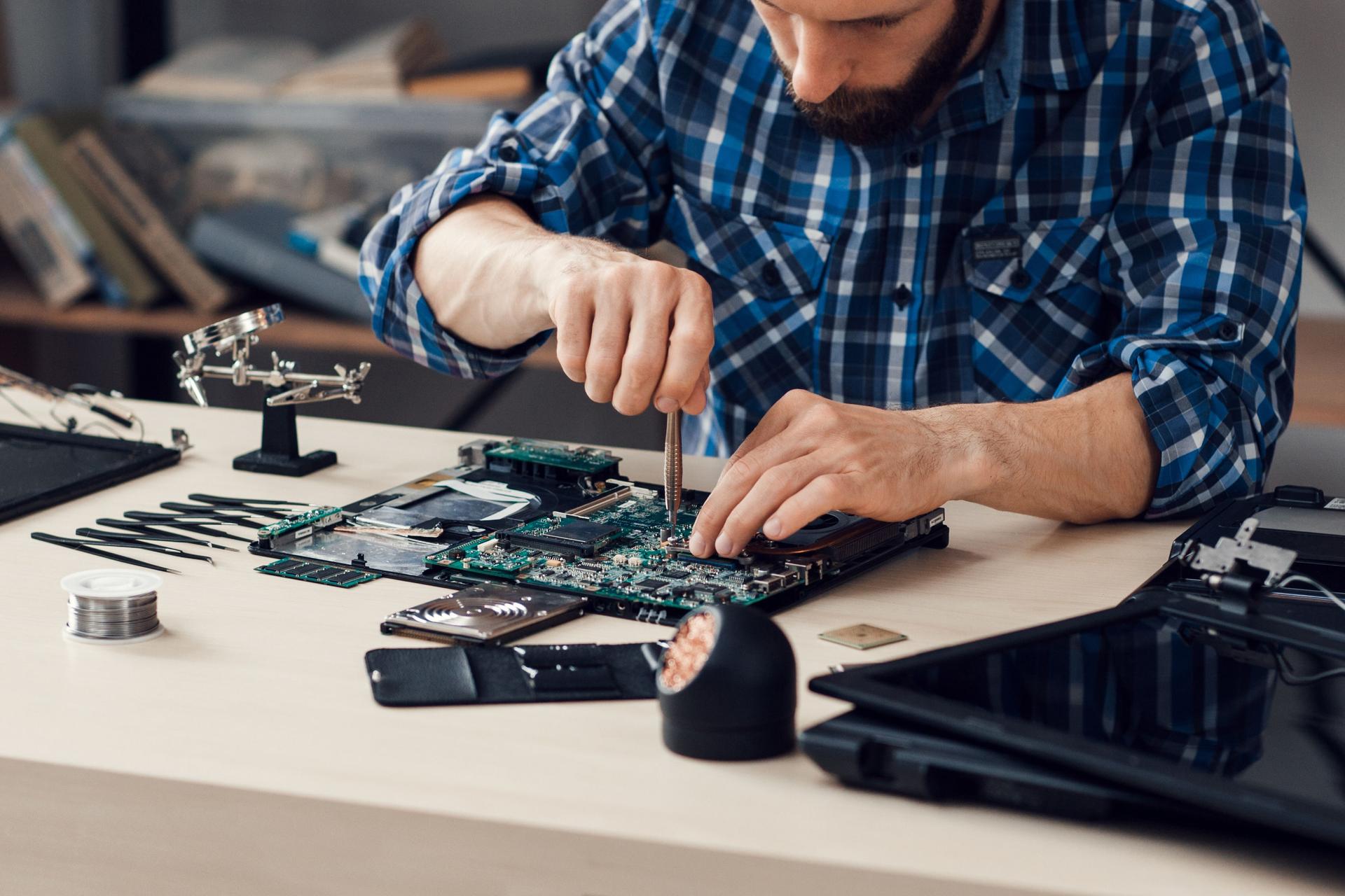 Laptop disassembling with screwdriver at repair